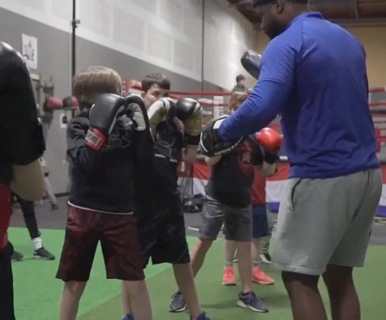 Children participating in the Books & Hooks After School Program's boxing class in Westminster MD, practicing jabs and hooks with a coach's guidance to improve physical fitness and self-discipline as part of a comprehensive after school program.